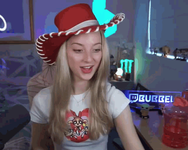 a girl wearing a cowboy hat and a shirt that says ' burbel '