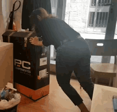 a woman is standing next to a box that says pc componentes