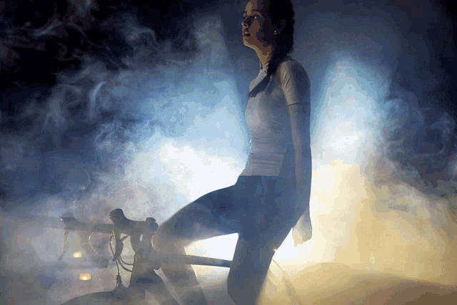 a woman is kneeling on a bicycle in a dark room