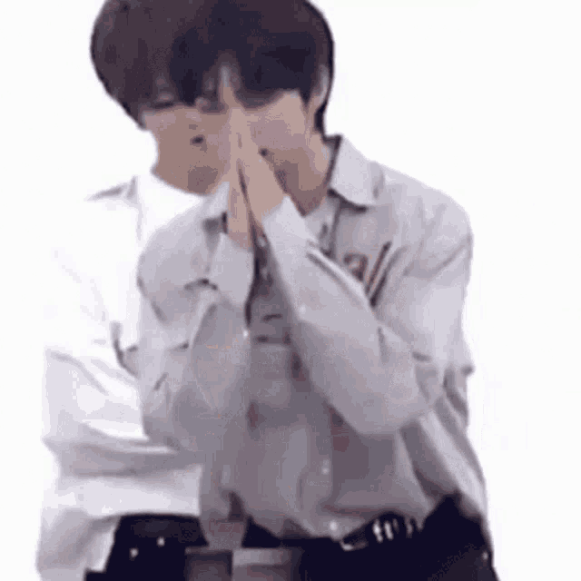 a couple of men are standing next to each other with their hands together .