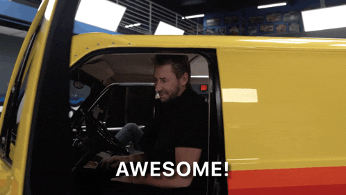 a man is sitting in a yellow van and the word awesome is on the screen