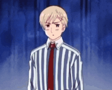 a young man in a striped shirt and tie is standing in front of a blue curtain .