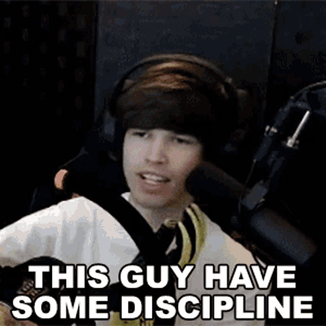 a man wearing headphones is sitting in front of a microphone and says `` this guy have some discipline '' .