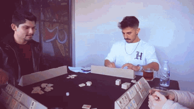 a man in a white shirt with the letter h on it