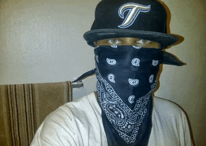 a person wearing a bandana and a hat with a letter t on it