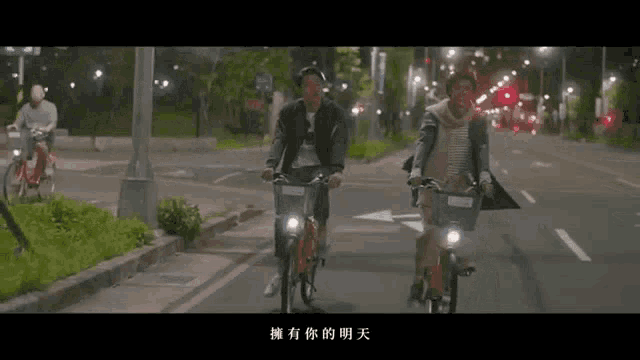 two people riding bicycles down a street with chinese writing on the bottom