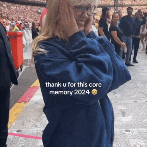 a woman covering her ears with her hands with the words thank u for this core memory 2024 on her sleeve