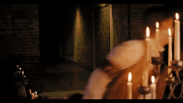 candles are lit in a dark room with a brick wall behind them