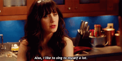 a woman is sitting in a kitchen talking about singing to herself .