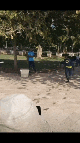a man in a batman costume is walking on a sidewalk
