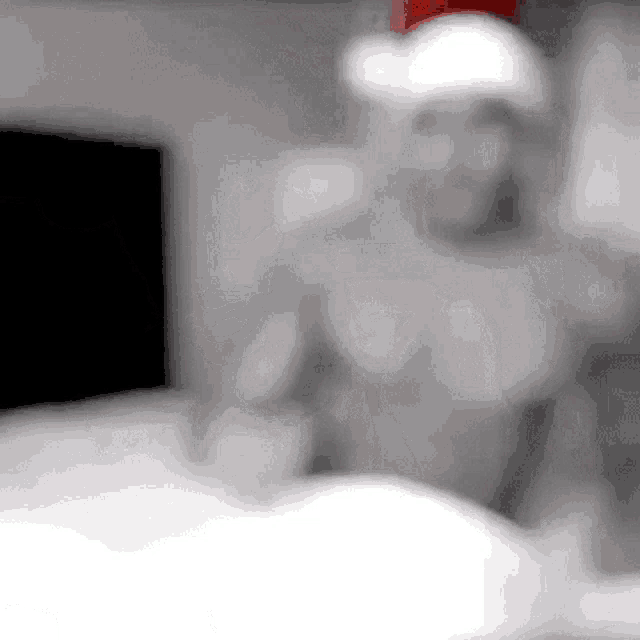 a shirtless man wearing a santa hat is standing in a room .