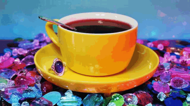 a cup of coffee sits on a saucer surrounded by colorful stones