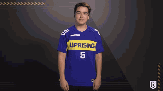 a young man wearing a blue and yellow uprising jersey