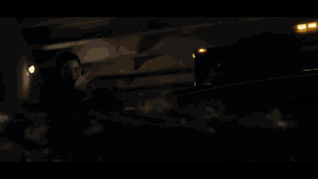 a woman in a black dress is standing in the dark