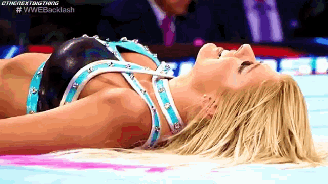 a female wrestler is laying on the ground with the words #wwebacklash on the bottom