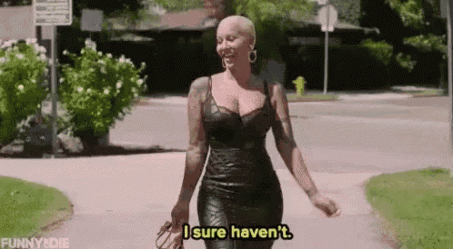 a woman in a black leather dress is walking down a sidewalk .