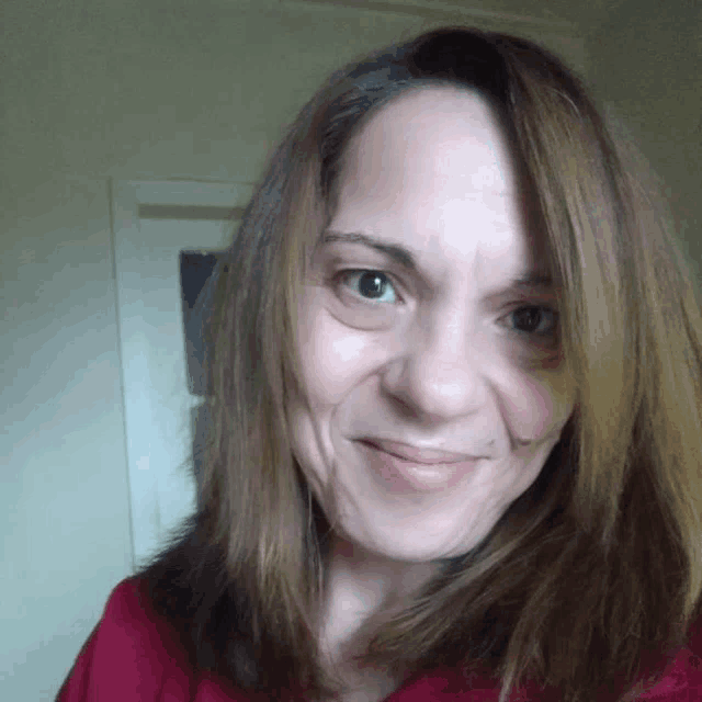 a woman with long brown hair smiles for the camera