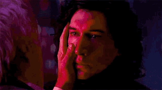 a close up of a man 's face with his hand on it .