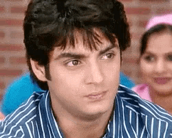 a man wearing a blue and white striped shirt is looking at the camera