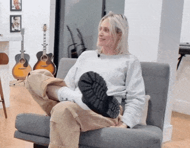 a woman is sitting in a chair with her feet up