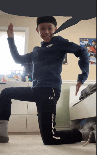 a boy wearing a blue nike sweatshirt and black pants with the letter g on the side