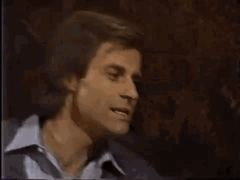 a close up of a man 's face in a dark room on a tv screen .