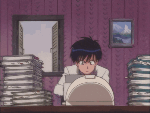 a man is sitting in front of a stack of books