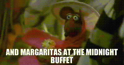 a close up of a muppet wearing a hat and a flower .