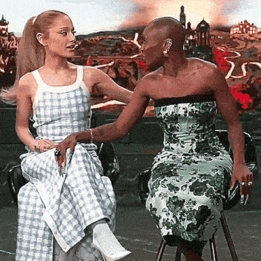 two women are sitting next to each other on a chair and talking .