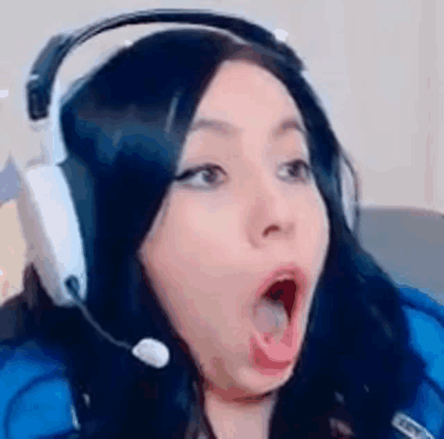 a woman is wearing headphones and making a funny face .
