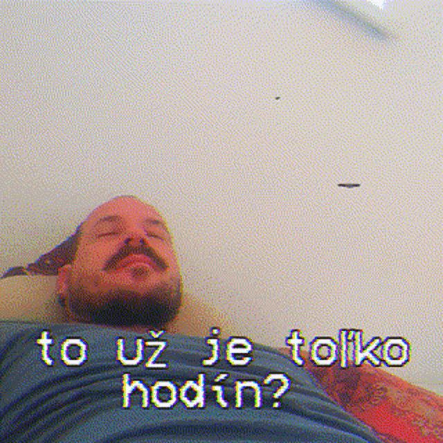 a man with a beard is laying on a bed with the words to uz je toliko hodin written above him