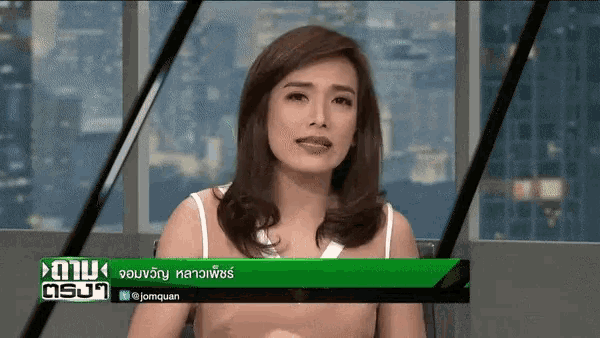 a woman is sitting in front of a screen that says " jomquan "