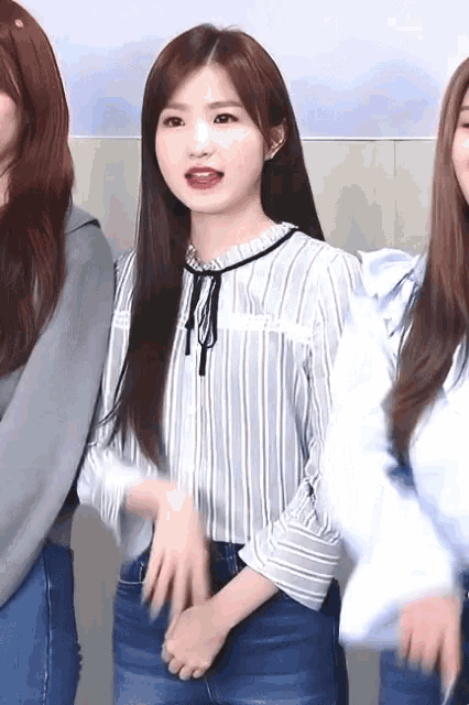 a girl wearing a striped shirt and blue jeans