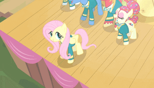 a group of ponies are standing on a stage with a pink curtain