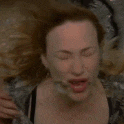 a woman is making a funny face with her eyes closed .