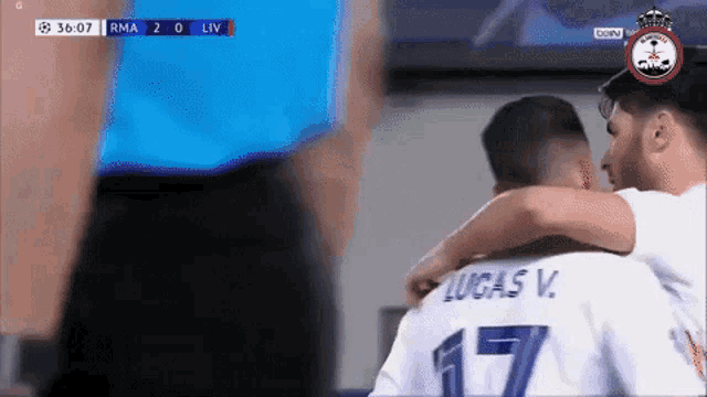 two soccer players hugging each other and one has the number 17 on his back