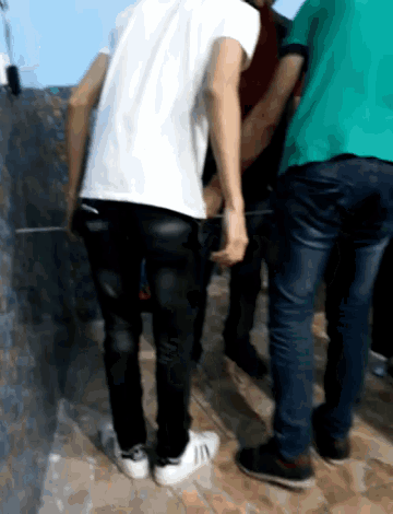a man in a white shirt is standing next to two other men