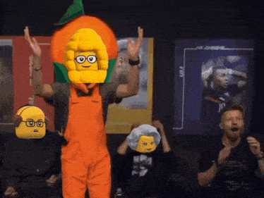 a man in an orange overalls with a corn on the cob head