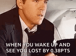 a man in a suit and tie is sitting in a car talking to someone .