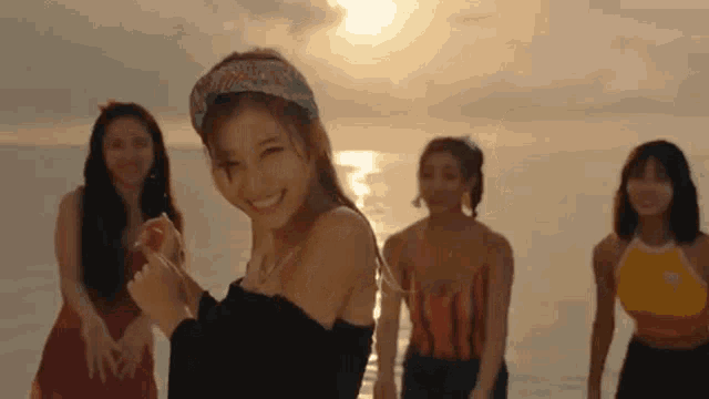 a group of young women are standing on a beach .