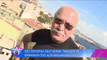a man wearing sunglasses and a mustache is standing in front of a sign that says magazin 8 e