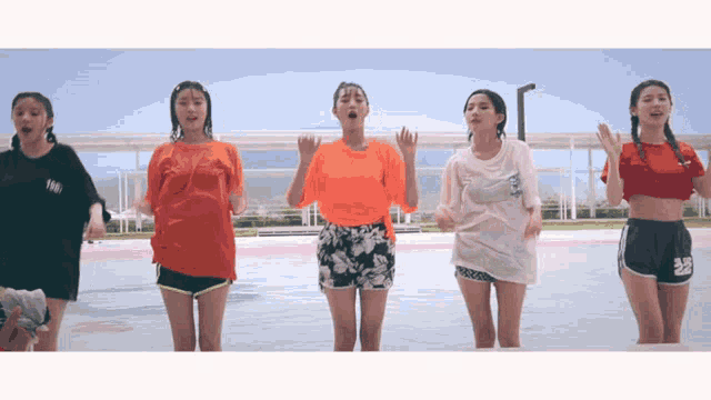 a group of girls are standing in a pool wearing wet clothes and shorts with the number 28 on them