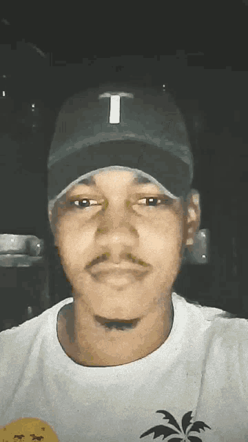 a man wearing a hat with a letter t on it