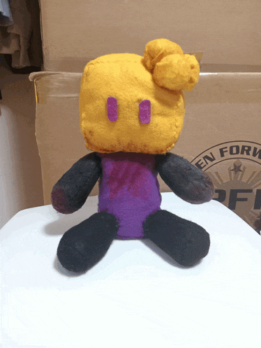 a stuffed animal is sitting in front of a cardboard box that says " en form "