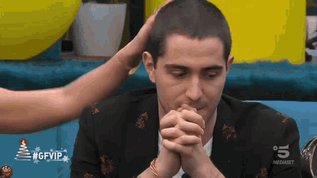 a man with his hands folded and a #gfvip logo on the bottom right