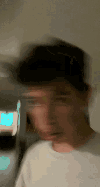a blurry picture of a man 's face with a blue sign in the background