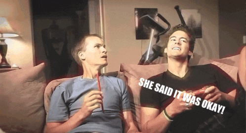 two men sitting on a couch with the words she said it was okay behind them