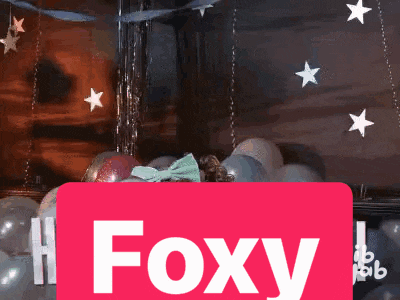 a red sign that says foxy is surrounded by balloons