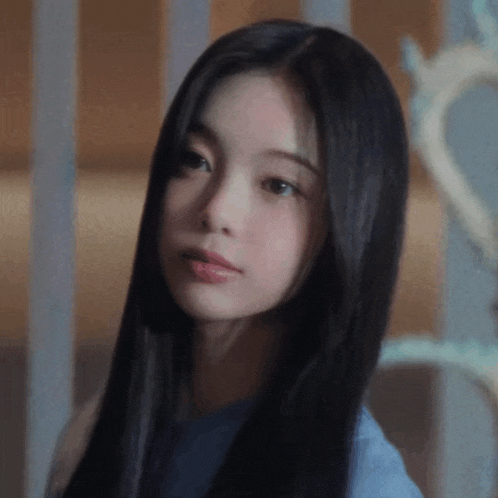 a close up of a young woman with long black hair looking at the camera .