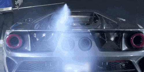 a silver sports car is being sprayed with a blue liquid